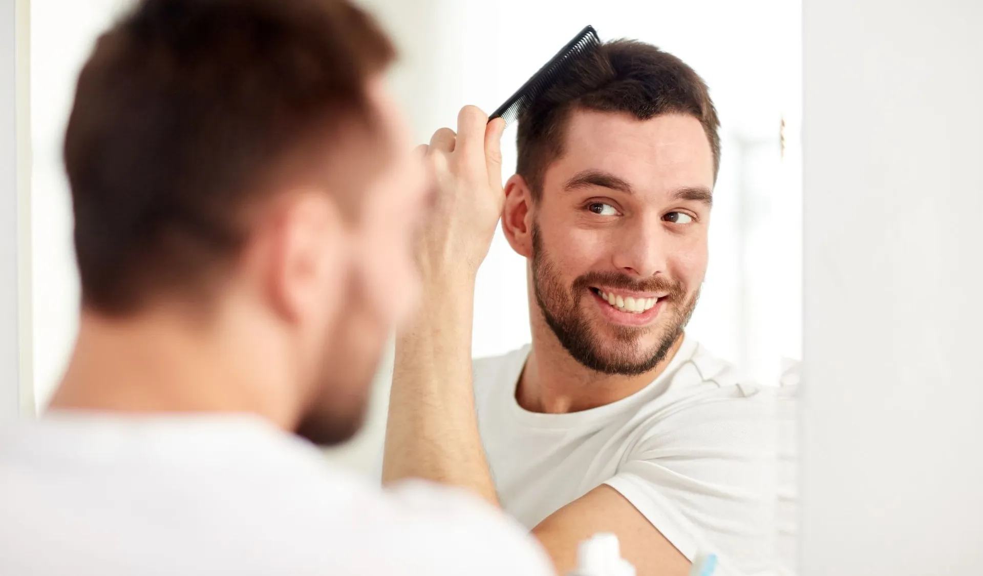 man-smile-at-mirror-while-brushing-hair-compressed